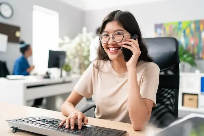 Mandarin-speaking Student Advisor on the phone facing her laptop