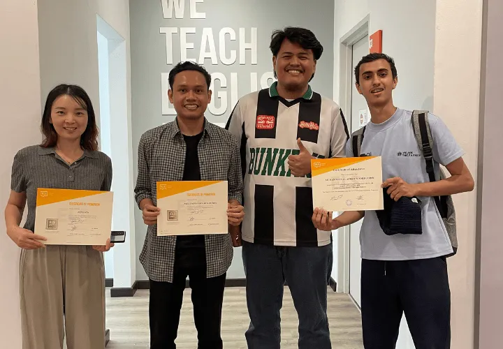 A group of 4 ELS students happily holding up their ELS certificates