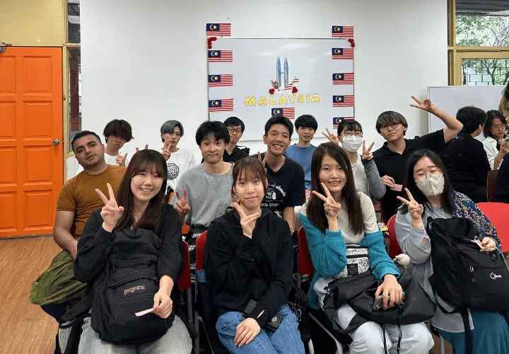 A group of smiling ELS students waiting for their graduation ceremony